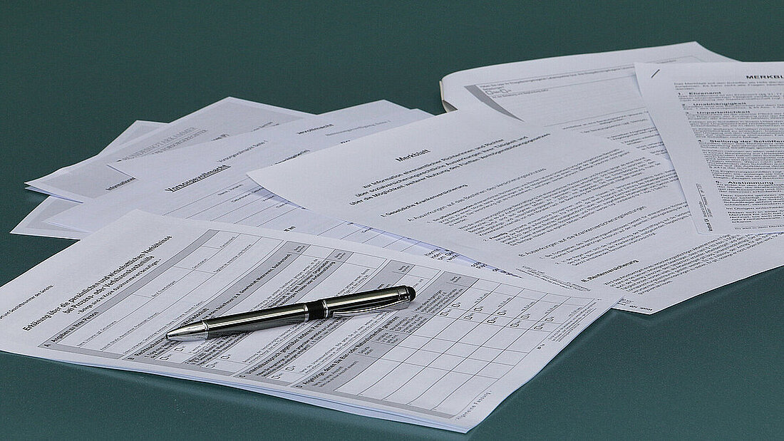 Papierformulare auf einem Tisch mit Stift.